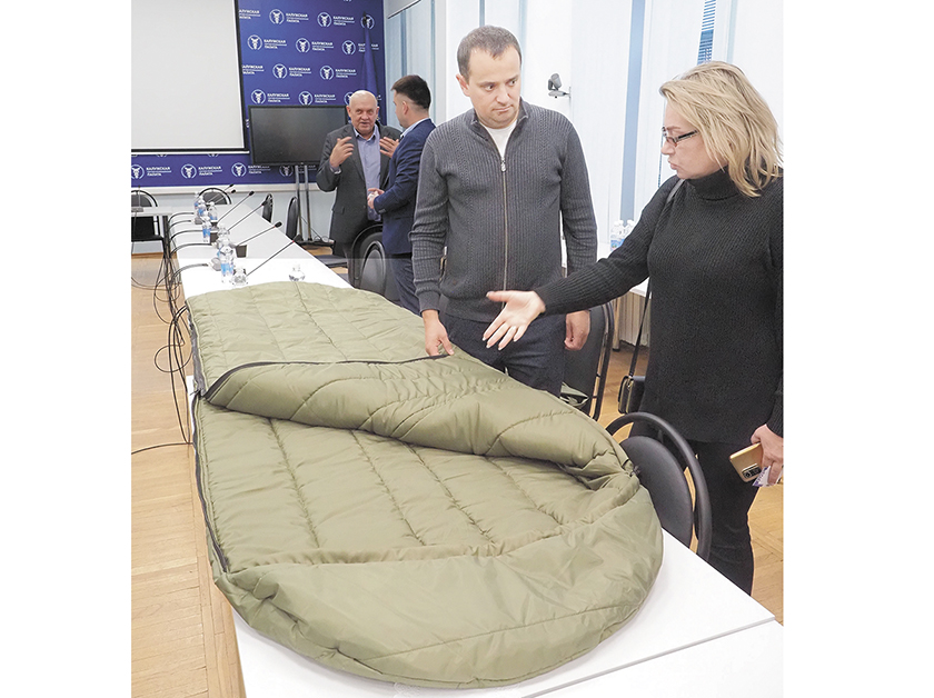 Евгений Махтей показывает сделанный на его предприятии армейский спальный мешок.jpg