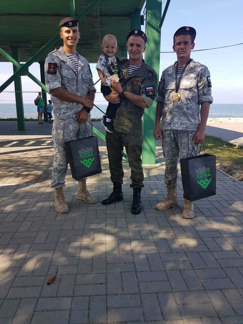 Максим Гуз в центра с сыном на руках.jpg