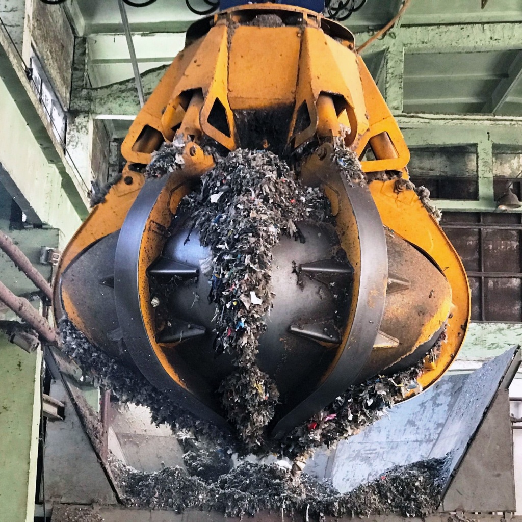 Кран захватывает сортированные ТО для улилизации в печи.jpg