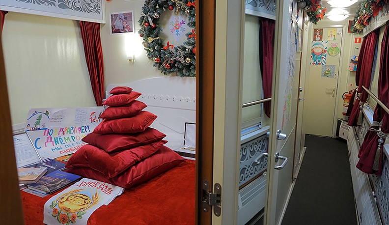 В ходе экскурсии по сказочному поезду маленькие калужане узнали, где спит Дед Мороз. И это вовсе не купе, а специальная комната с красивой кроватью, изготовленной из дерева. На ней лежит чудесная перина, которая сделана из ароматных трав. Семь подушек, сл